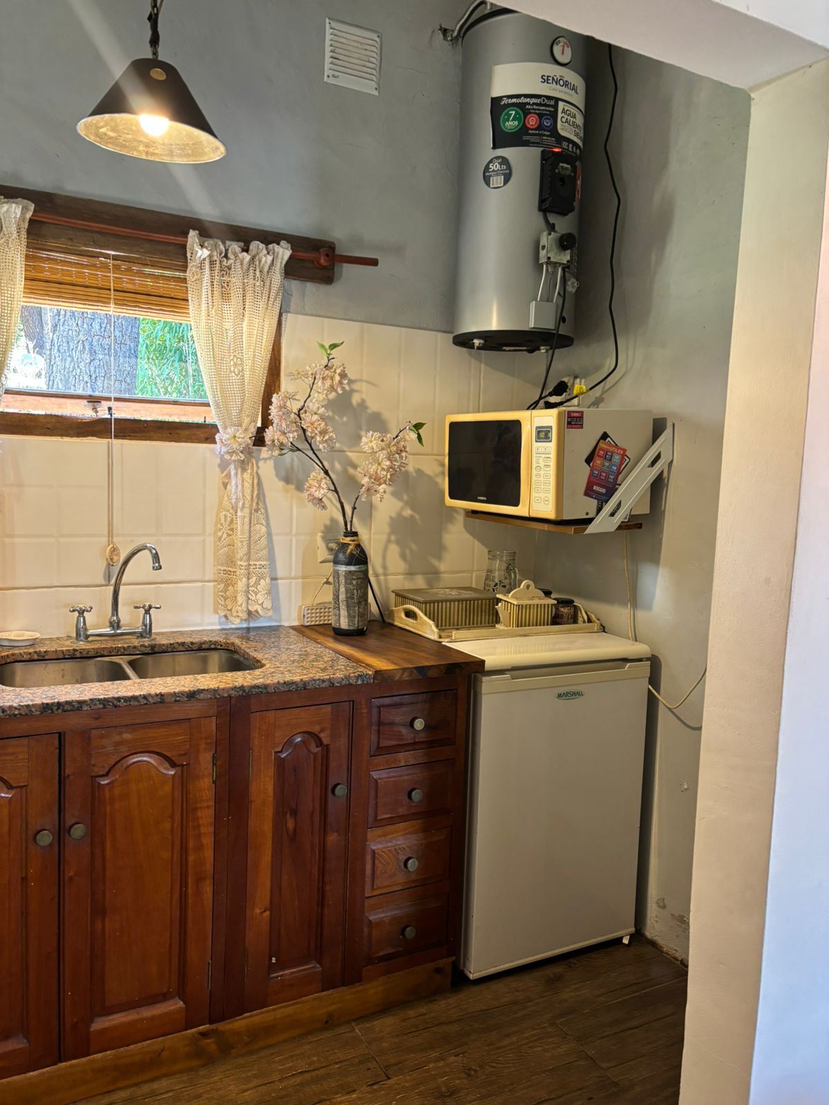 Cocina con heladera, microondas y mesada